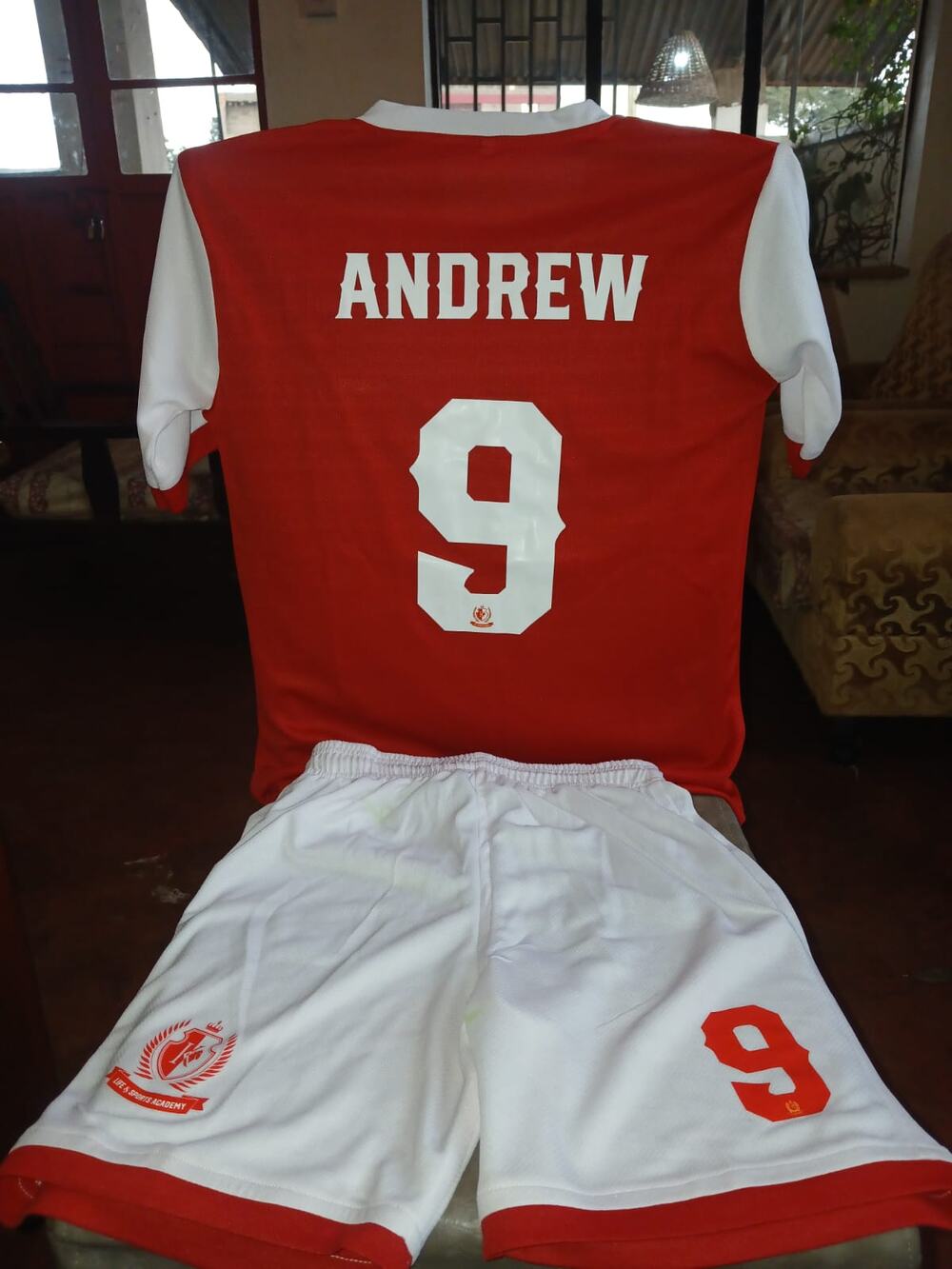 An LSA home shirt with a player's name and number 9 on the back, above white shorts with a red hem